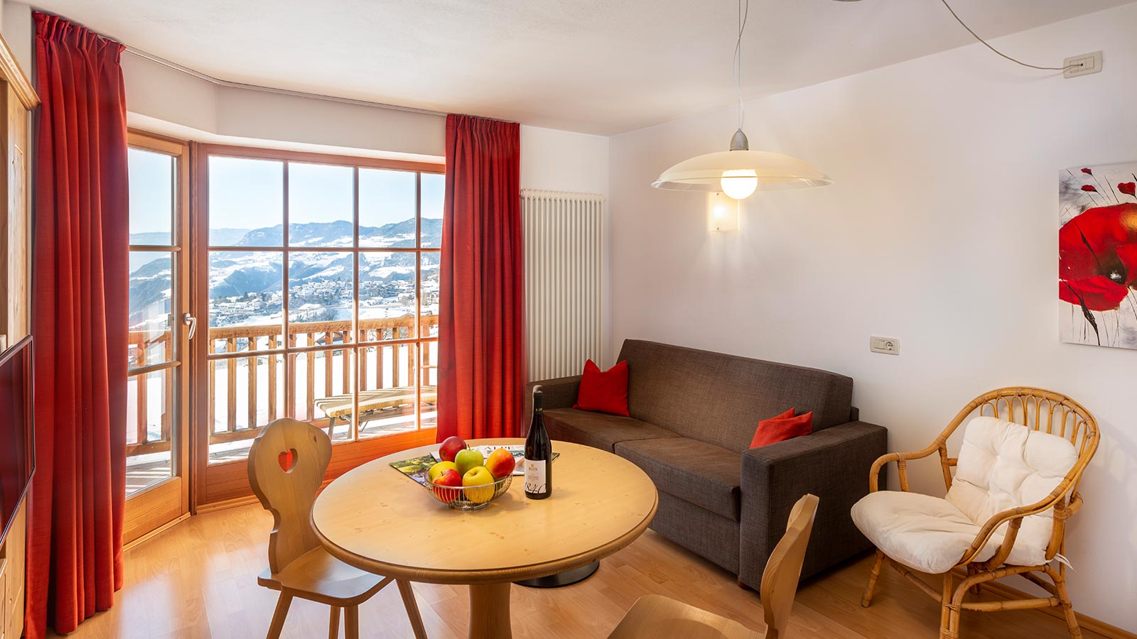 Il soggiorno di uno degli appartamenti a Fiè allo Sciliar con vista sulla valle innevata